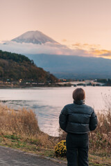 Woman tourist with Fuji Mountain at Lake Kawaguchi, happy Traveler sightseeing Mount Fuji in Fujikawaguchiko, Yamanashi, Japan. Landmark for tourists attraction. Japan Travel, Destination and Vacation
