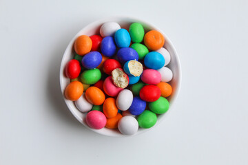 Biscuit balls coated by colorful chocolate. Isolated on white background, flat lay or top view