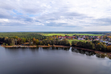 Aerial shot of beautiful lake surrounded by forest in a calm autumn day. Germany. - 755682836