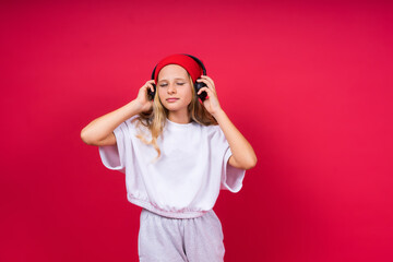 Child music concept. Teenager girl dances in rhythm of melody, listens song in headphones