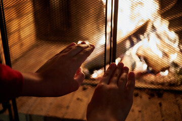 Human hands warming at fire