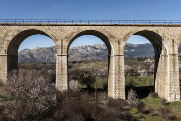 Stone train bridge with views of the Madrid mountains