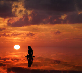 Silhouette sitzende Frau Körper - Spiegelung Meer und Sonnenuntergang - Meditation und Gesundheit