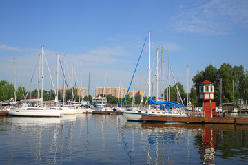 Pier, many yachts and boats on river in town on sunny summer day