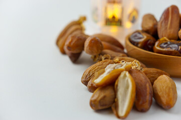 a close-up photo of dried dates served on a wooden bowl and white lantern isolated on white background