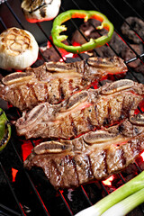 Grilled Delicacy: 4K Ultra HD Image of Short Rib on Charcoal Grill with Roasted Garlic