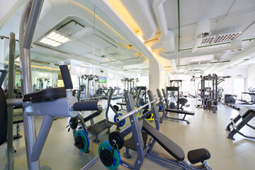 Fototapeta na wymiar Empty modern gym with new shiny fitness equipment, big mirror for sport training