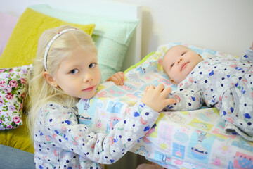 Little girl and her baby sister in same dresses in bedroom of home