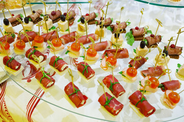 Many canapes - cold appetizers are on table with white cloth
