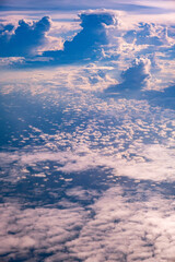 An endless sea of clouds through an airplane window; blue sky cloudscape