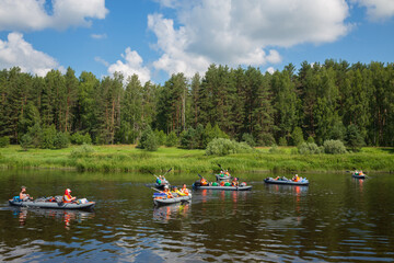 Fototapeta na wymiar Tourists on boats on river. Tvertsa - river in Tver region of Russia. Length - 188 km. The river is used by tourists for canoeing
