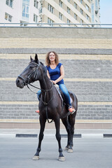 Young woman on horseback on road at residential complex