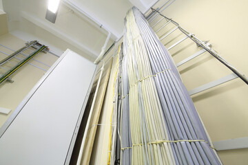 Empty storage at communications room with many cables and ladder