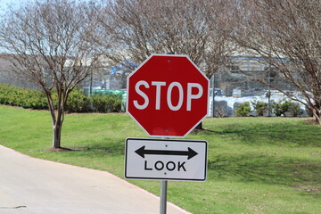 A busy roadway is one of few exits from the hike and bike trail that links with other major trails. Bikes are the problem here and Look  sign has been added.