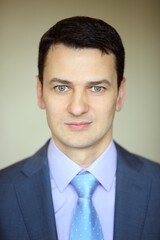 Smiling elegance brunet man in business suit with tie in studio