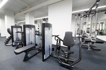 Fototapeta na wymiar Fitness center with sport equipment for chest press and seated row
