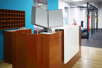 Stylish reception with wooden counter and blue walls in fitness center