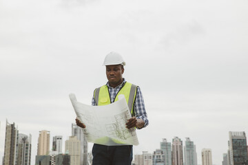 Engineers with draft plan of building on constructing site. Engineer working on building site. Engineer working with drawing System plan document