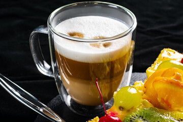 A glass of coffee on a black background. Latte or cappuccino