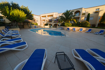  Beach chairs near swimming pool of luxury hotel. Summer morning