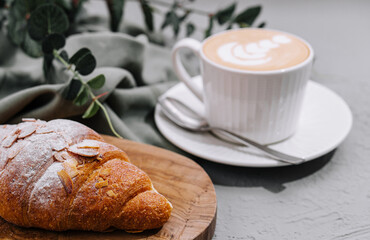 Almond Croissant on plate with cup of coffee