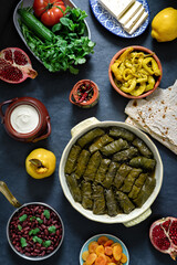 National Caucasian Armenian food. Seth from different dishes:delicious dolma - stuffed grape leaves with rice and meat,beans,jogurt,pomegranate, bread,pickled peppers,quince,cheese,apricots. Top view.