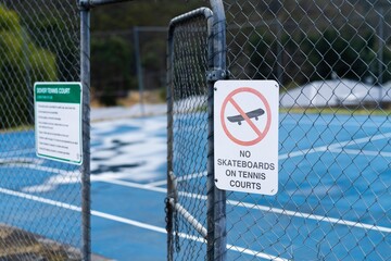 tennis court rules on a sign saying no skateboards and no dogs in australia