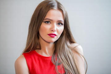 Beautiful young girl with long hair in red dress