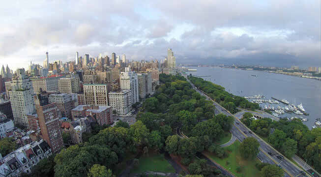 Cars ride by Henry Hudson Parkway near Riverside Park and 79th Street Boat Basin at summer evening. Aerial view