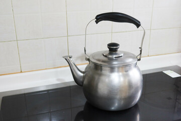 silver stainless steel pot kettle with Whistle function for boil water placing on the stove in...