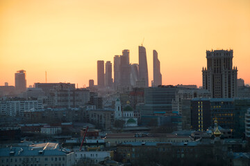 Obraz premium Panorama of roofs, domes of churches and skyscrapers during sunset in Moscow