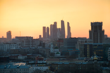 Panorama of roofs, domes of churches and skyscrapers during sunset in Moscow