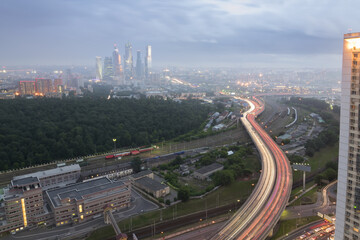 Railroad and modern highway at summer cloudy evening in Moscow, Russia