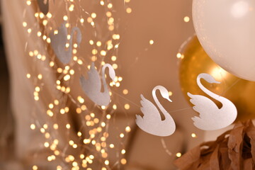Elegant white swan silhouettes with glowing lights and festive decorations