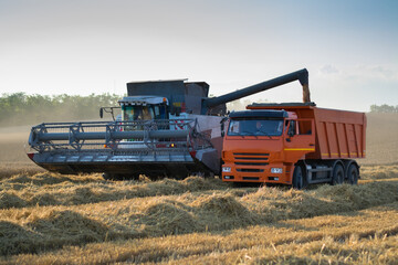  Harvester loading grain into truck, 