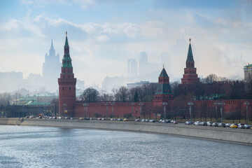 Kremlin embankment, cars on road, city in fog in Moscow, Russia