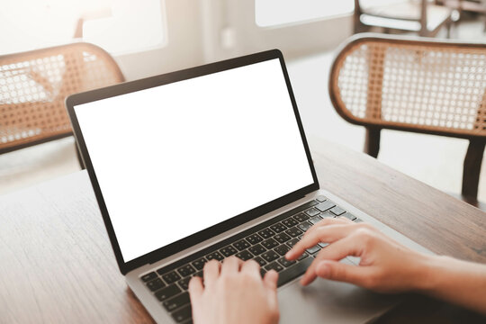 Close-up image of a woman sitting in the cafe and using her laptop.  laptop white blank screen mockup for display your graphic banner...