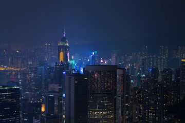 Night skyscrapers with bright illumination and mountains in Hong Kong, China, view from Queen Garden