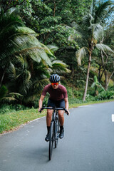 A young woman cyclist riding her gravel bike in the mountains.