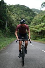 Fototapeta premium A young woman cyclist riding her gravel bike in the mountains.
