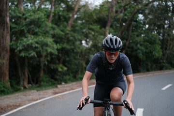 A young woman cyclist riding her gravel bike in the mountains.