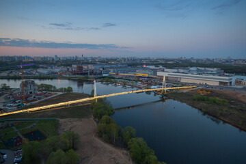 Fototapeta premium Suspended footbridge Pavshinskaya floodplain evening in Krasnogorsk, Russia