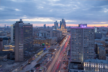 Fototapeta na wymiar New Arbat Street, highway with moving cars, skyscrapers at evening in Moscow, Russia