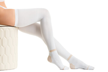 Legs in white compression stockings on a white background, thromboembolism, varicose veins.