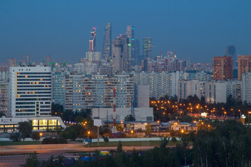 Sleeping area with illuminated road, tall buildings at night in Moscow, Russia