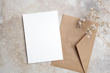 Wedding invitation card mockup with dry gypsophila flowers and envelope, copy space for card design...
