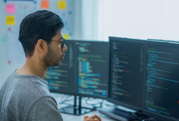 Asian promt engineer develope coding app with software data sitting in front of computer monitor at office - 755745648