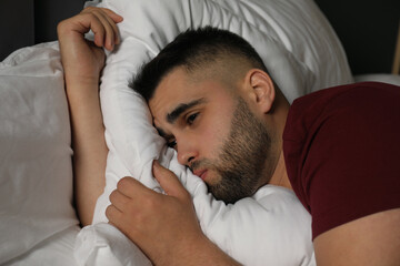 Obraz na płótnie Canvas Sad man lying on bed at home