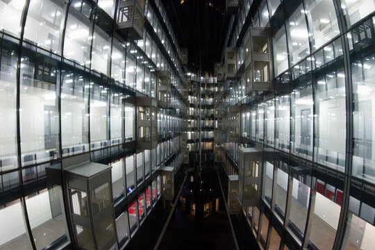Beautiful illuminated windows with relfection in glass - modern building at night in city