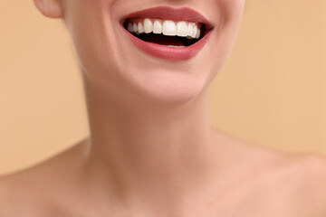 Obraz premium Woman with beautiful lips smiling on beige background, closeup